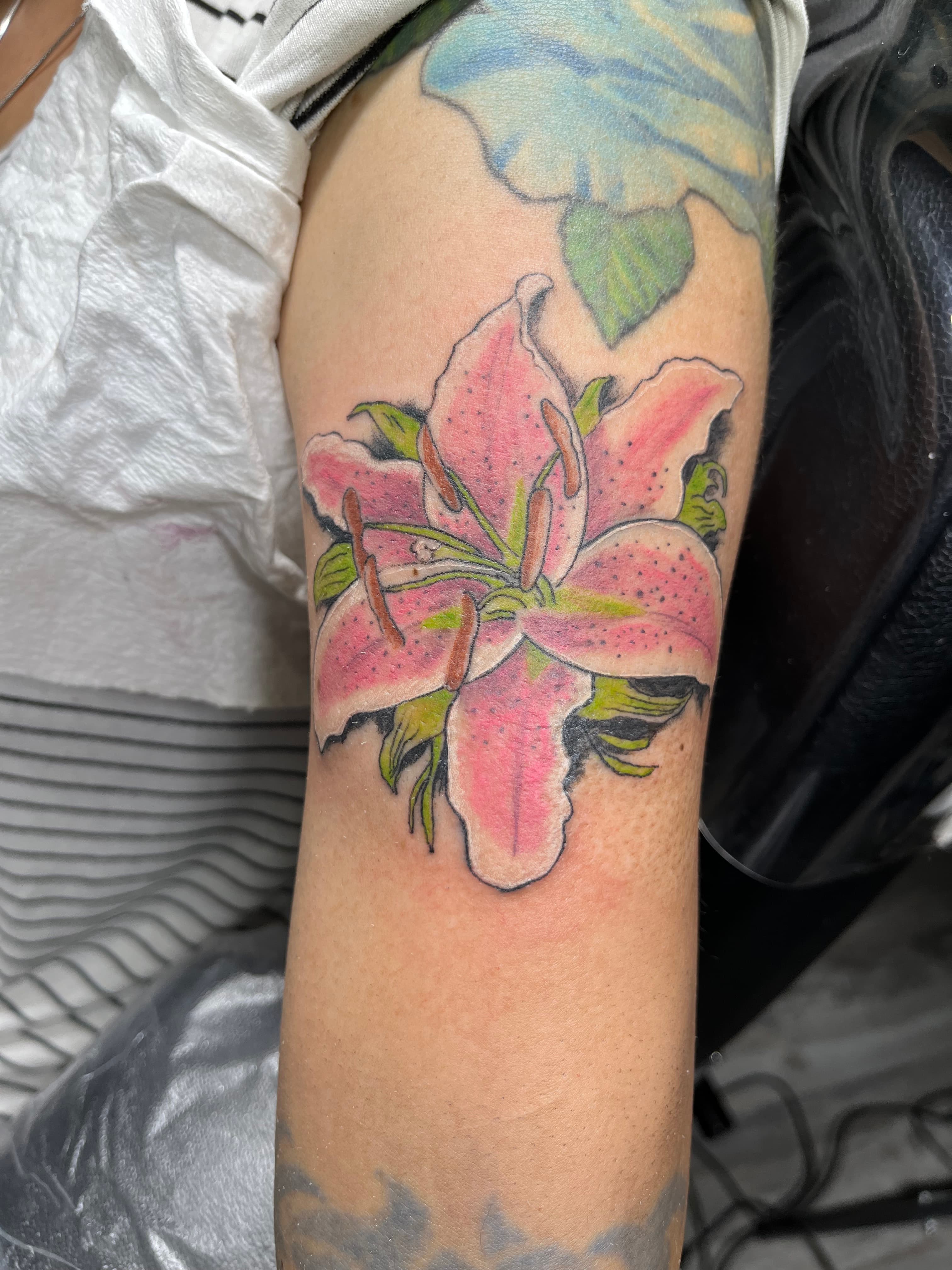Color stargazer lily flower tattoo on arm by tattoo artist Maple Valley WA